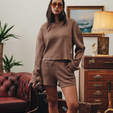 Female model wearing a brown waffle-patterned cropped sweatshirt with a stitched-on material label.