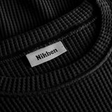 Close up on round neck on a black waffle-patterned cropped sweatshirt