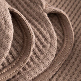 Close up of leg on brown waffle-patterned short-length shorts.